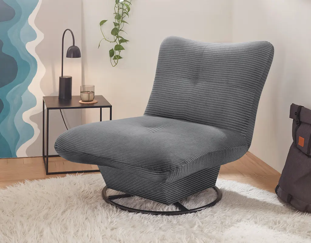 Bequemer grauer Lounge-Sessel mit Cordbezug in modern eingerichteter Ecke mit Beistelltisch, Lampe und Wandbild. Moderner Polstersessel für gemütliche Wohnbereiche und stilvolle Einrichtung.